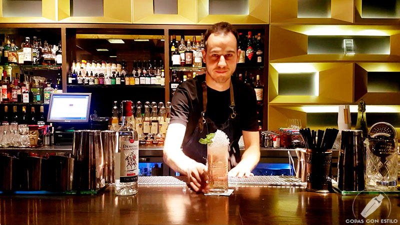 El bartender de coctelería Mario Villalón presentando su cóctel con pisco