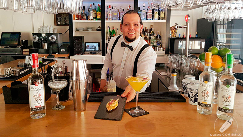 El bartender de coctelería Carlos Villanueva presentando su cóctel con pisco