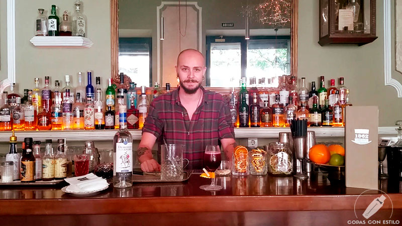 El bartender de coctelería Adrián Benito presentando su cóctel con pisco