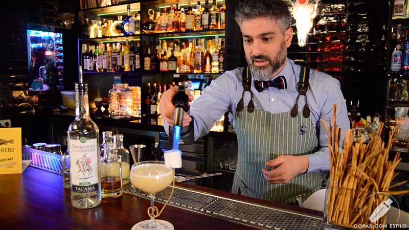 El bartender Diego Cabrera flambeando el cóctel con pisco en la coctelería Salmon Guru (Madrid)